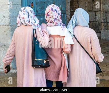 JERUSALEM, Israel/25. Nov. 2019: Drei muslimische Frauen auf, dekorative hijbas (kopfbedeckungen durch das islamische Gesetz unterstellt), Eintritt in die Altstadt von Jerusalem Stockfoto