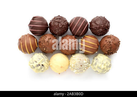 Blick von oben auf die verschiedenen Schokolade Pralinen auf weißem Hintergrund Stockfoto