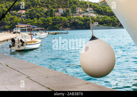 Pucisca Stadt auf Brac in Kroatien, Aussicht auf einen sonnigen Tag im Sommer. Der Hafen mit der berühmten Kalkstein von der Insel und ein Boot einen Fender Esprit. Beaut Stockfoto