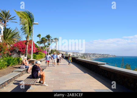 MASPALOMAS, SPANIEN - 23. JANUAR 2019: Urlauber an der Strandpromenade von Playa del Ingles, Maspalomas, auf den Kanarischen Inseln, Spanien, eine beliebte Winter Stockfoto