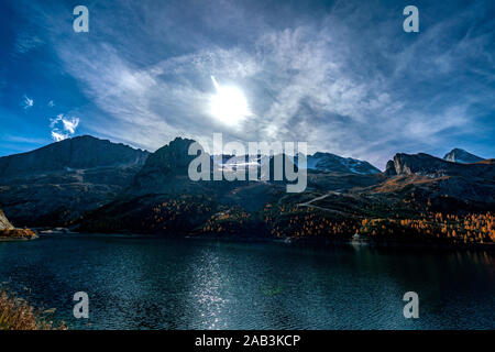 Mit Blick auf den Fedaia See am Fuße der schneebedeckten Marmolada Berge in Südtirol auf einem sonnigen und klaren Herbsttag Stockfoto