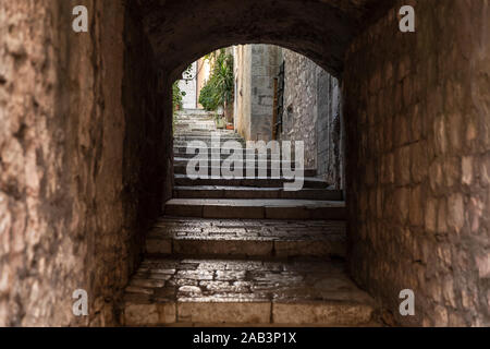 Alte mediterrane Straße mit einem Bogen Treppen in Korcula. Rauer Stein Häuser und Fassaden und grünen Pflanzen in Dalmatien, Kroatien. Historischer Ort creati Stockfoto