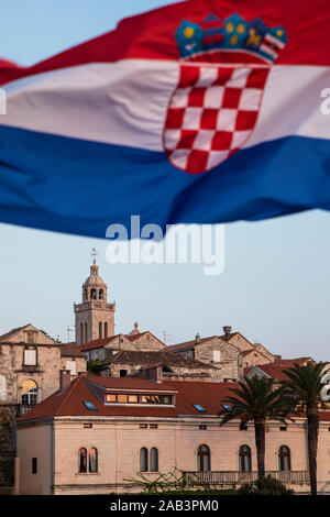 Insel Korcula mit der Kathedrale und der kroatischen Flagge, Detail shot bei Sonnenuntergang im Sommer. Schöne alte venezianische Architektur und Palmen creat Stockfoto