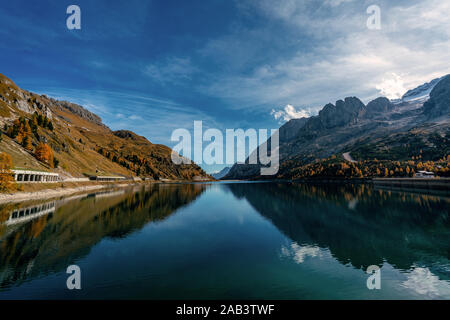 Mit Blick auf den Fedaia See am Fuße der Marmolada Berge in Südtirol auf einem sonnigen und klaren Herbsttag Stockfoto