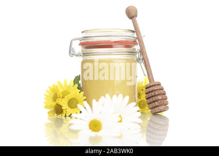 Honigglas mit Honiglˆffel und Blumen | Honigtopf Honig mit Löffel und Blumen | Stockfoto