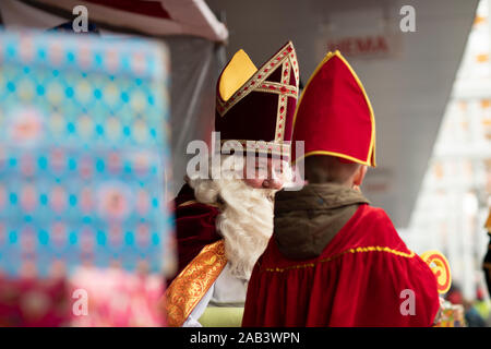 Eindhoven, Niederlande, 23. November 2019. Sinterklaas seine roten Kostüm aufruf der nächsten Kind tragen. Kleines Kind trägt einen Sint Kostüm. Niederländische fe Stockfoto