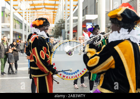 Eindhoven, Niederlande, 23. November 2019. Happy Pieten tragen ihren bunten Kostümen in einer Blaskapelle spielen Sinterklaas Musik. Niederländische festi Stockfoto