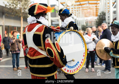 Eindhoven, Niederlande, 23. November 2019. Ein Piet seine bunte grünen Kostüm in einer Blaskapelle spielen Sinterklaas Musik auf der Basis Dru Stockfoto