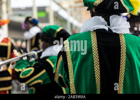 Eindhoven, Niederlande, 23. November 2019. Pieten tragen bunte grüne Kostüme in einer Blaskapelle Sinterklaas Musik zusammen zu spielen. Niederländische ev Stockfoto