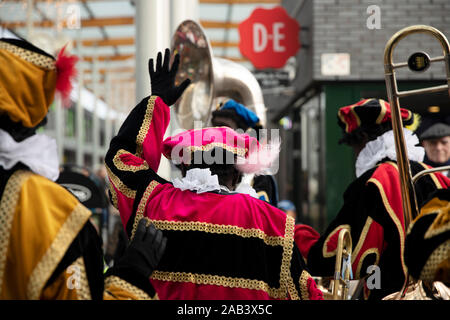 Eindhoven, Niederlande, 23. November 2019. Happy Pieten tragen ihren bunten Kostümen in einer Blaskapelle spielen Sinterklaas Musik und setzen Stockfoto