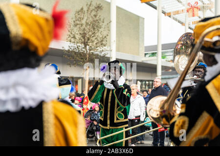 Eindhoven, Niederlande, 23. November 2019. Pieten tragen ihren bunten Kostümen in einer Blaskapelle spielen Sinterklaas Musik auf einer Trompete. Dutc Stockfoto