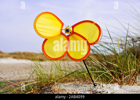 Ein defektes / Windrad am Strand an der Ostsee | ein kaputtes Spielzeug Windmühle auf dem Strand an der Ostsee | Stockfoto