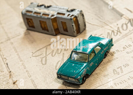 Zwei Spielzeugautos mit dem werbeteil einer alten, vergilbten Zeitung | Zwei Spielzeugautos auf der Werbung Teil eines alten, vergilbten Zeitung | Stockfoto