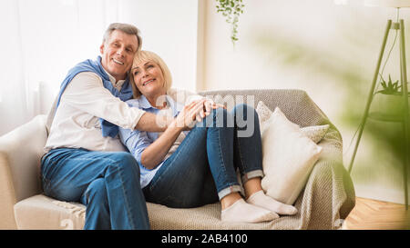 Liebe lebt für immer! Liebevolle senior Paar, sitzen auf dem Sofa Stockfoto