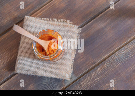 Frisch zubereitete Karotte Marmelade im Glas auf hölzernen Tisch. Stockfoto