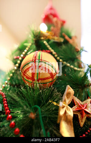 Neues Jahr bunte Dekoration Schmuck am Weihnachtsbaum. Zimmer zu Weihnachten Feier eingerichtet, Urlaub Szene mit verschiedenen Formen, Kugeln am Baum. Stockfoto