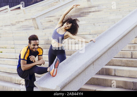 Glückliche junge Läufer paar Stretching auf Stadt Treppen vor dem Ausführen, Fitness, urbane Sportarten Workout und gesunden Lebensstil Konzept, kopieren Platz für Text Stockfoto