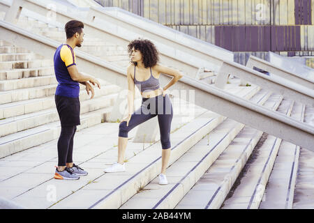 Interracial Paare von Läufern Ausruhen nach dem Zug auf der Stadt Treppen. Fitness, urbane Sportarten Workout und gesunden Lebensstil Konzept, kopieren Sie Raum für Tex Stockfoto