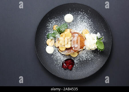 Süße Pfannkuchen mit Bananen in Karamellsauce und Schlagsahne Stockfoto