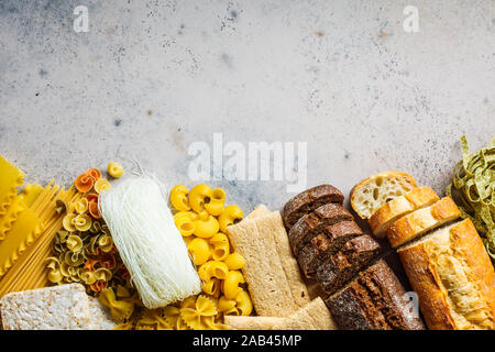 Verschiedene pasta Hintergrund. Brot und verschiedene Arten von Nudeln auf einem grau-blauen Hintergrund, kopieren. Stockfoto