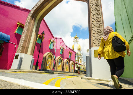 Atemberaubende Aussicht auf die Moschee Masjid Sultan im Hintergrund und einem Defokussierten muslimische Frau wandern im Vordergrund. Stockfoto