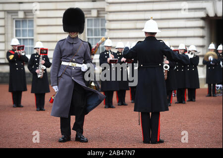 Die Royal Navy Officer (rechts) neben einem Scots Guards, wie Segler aus der Royal Navy durchführen, den Wachwechsel Zeremonie im Buckingham Palace, London, zum zweiten Mal in seiner 357-jährigen Geschichte. Stockfoto