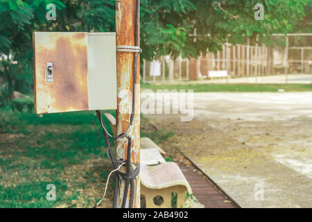 Alten rostigen Elektrische Power Control Box auf verrostete elektrische Pole im öffentlichen Park. Stockfoto