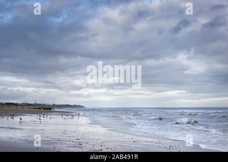 Ein düsterer und stürmischer Wintertag am Strand bei kaltem Wetter, Norfolk, East Anglia, Großbritannien Stockfoto