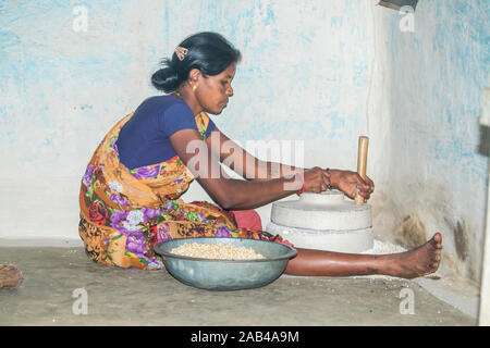 Sijhora, Madhya Pradesh, Indien - November 2019: Ländliche indische Frau mit der Mühle mahlen, Sijhora Madhya Pradesh Indien Mais. Stockfoto