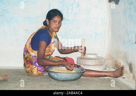 Sijhora, Madhya Pradesh, Indien - November 2019: Ländliche indische Frau mit der Mühle mahlen, Sijhora Madhya Pradesh Indien Mais. Stockfoto