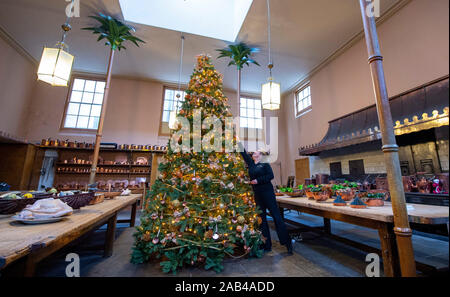 Brighton UK 25. November 2019 - Mitarbeiter Karen Antoni fügt einige Dekorationen für den Weihnachtsbaum in der Küche der Royal Pavilion in Brighton. Eine Reihe von geschmückte Bäume und ein Schlitten für Besucher ausprobieren kann um die berühmten seaside Retreat von König George IV diese festliche Jahreszeit gebaut. Foto: Simon Dack/Alamy leben Nachrichten Stockfoto