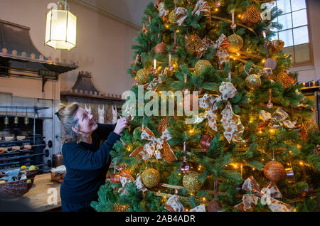 Brighton UK 25. November 2019 - Mitarbeiter Karen Antoni fügt einige Dekorationen für den Weihnachtsbaum in der Küche der Royal Pavilion in Brighton. Eine Reihe von geschmückte Bäume und ein Schlitten für Besucher ausprobieren kann um die berühmten seaside Retreat von König George IV diese festliche Jahreszeit gebaut. Foto: Simon Dack/Alamy leben Nachrichten Stockfoto