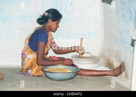 Sijhora, Madhya Pradesh, Indien - November 2019: Ländliche indische Frau mit der Mühle mahlen, Sijhora Madhya Pradesh Indien Mais. Stockfoto