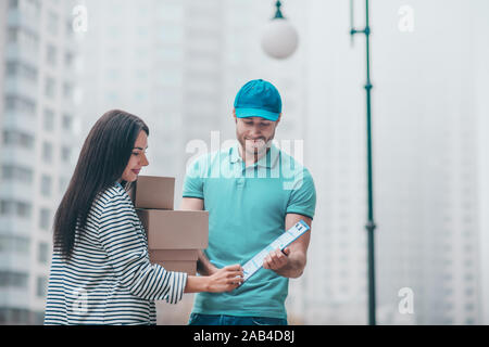Lieferung Mann mit Kappe Erklärung geben zu Kunde Stockfoto