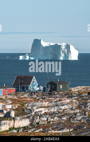 Bunte grün blau Holzhäuser mit Eisbergen im Hintergrund. Rodebay, auch bekannt als oqaatsut ist ein Fischerdorf, Siedlung nördlich von Ilulissat. Disco Stockfoto