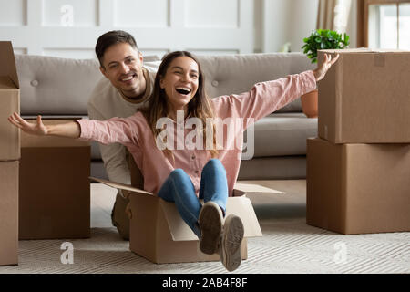 Glückliches junges paar Reiten in Feld am Umzugstag Stockfoto