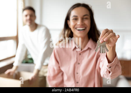 Glückliche junge Frau halten Tasten verlagern mit Mann und Boxen Stockfoto