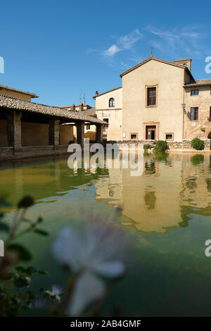 Das antike Thermalbad Dorf Bagno Vignoni und die Kirche von San Giovanni Battista in Val d'Orcia in der Toskana Italien - Bäder von St. Catherine Stockfoto