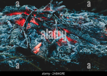 Brennendes Feuer mit kleinen Flammen und Asche Stockfoto