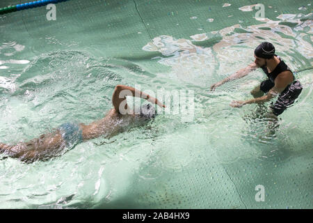 Mann, Schwimmunterricht mit einem Lehrer. Stockfoto