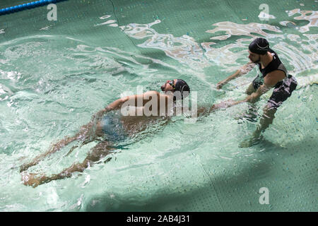 Mann, Schwimmunterricht mit einem Lehrer. Stockfoto