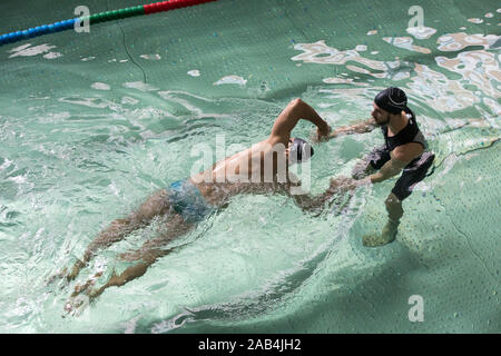 Mann, Schwimmunterricht mit einem Lehrer. Stockfoto