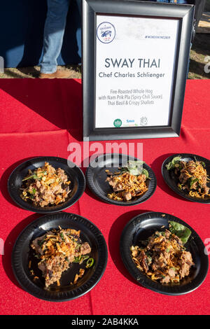 Austin, Texas, USA. 24. November 2019. Sway Thai bietet bis Fire-Roasted aufs Ganze mit Nam Prik Pla (würzige Chili Sauce), Thai Basilikum & knusprigen Schalotten. Wein und Schwein, ein Ereignis auf der Austin Essen und Wein Alliance, War im Camp Mabry, Sonntag Nachmittag statt. Besucher erhalten neue Kreationen auf einem traditionellen Schweinebraten von Spitzenköchen zu probieren. Die beliebtesten Gerichte und Getränke gewinnen ein Preisgeld. Credit: Sidney Bruere/Alamy leben Nachrichten Stockfoto