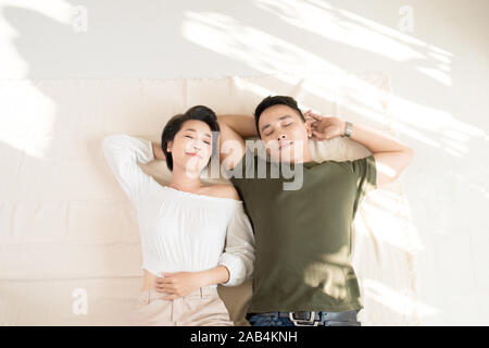 Junge glücklich Liebende asiatischen Paar Freund und Freundin auf dem Boden liegt. Stockfoto