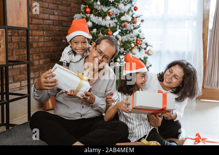 Großeltern und Kinder zusammen spielen am Weihnachtstag Stockfoto