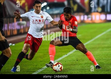 Brasilianische Fußballspieler Paulinho von Guangzhou Evergrande Taobao F.C., rechts, hält den Ball in der 28. Runde der Chinese Football Association Super League (CSL) gegen Shanghai SIPG in Guangzhou City, die südchinesische Provinz Guangdong, 23. November 2019. Guangzhou Shanghai SIPG Evergrande Taobao besiegt mit 2-0. Stockfoto