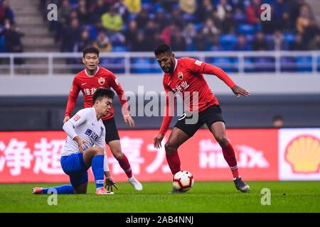 Brasilianisch-portugiesische Fußballspieler geboren Dyego Sousa von Shenzhen F.C., rechts, hält den Ball in der 28. Runde der Chinese Football Association Super League (CSL) gegen Tianjin TEDA in Tianjin, China, 23. November 2019. Tianjin TEDA zerschnitten Shenzhen F.C. mit 3-0. Stockfoto