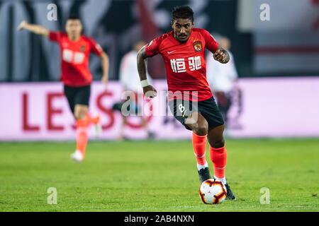 Brasilianische Fußballspieler Paulinho von Guangzhou Evergrande Taobao F.C., rechts, hält den Ball in der 28. Runde der Chinese Football Association Super League (CSL) gegen Shanghai SIPG in Guangzhou City, die südchinesische Provinz Guangdong, 23. November 2019. Guangzhou Shanghai SIPG Evergrande Taobao besiegt mit 2-0. Stockfoto