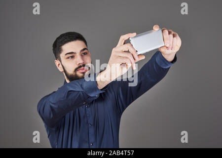 Glücklich lächelnde gut aussehender bärtiger junger Mann, selfie Stockfoto
