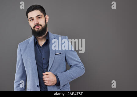 Portrait von freelancer Mann mit Bart in Jacke gegen graue Hintergrund Stockfoto